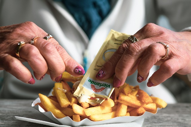 A helping of french fries with ketchup, a familiar ultra-processed snack. Processed foods like these tend to be very tasty and easy to eat quickly – traits that encourage overeating before satiety sets in.