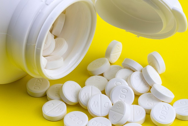 An open pill bottle spilling capsules, illustrating how even routine prescriptions (like memory supplements or acid-reflux medications) can carry unexpected risks for the aging brain.